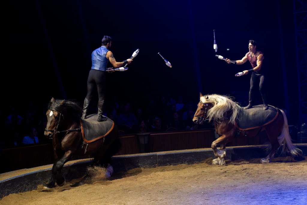 Deux hommes en train de jongler à dos de cheval